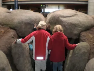 Mensen, op de rug te zien, bij hunebed
